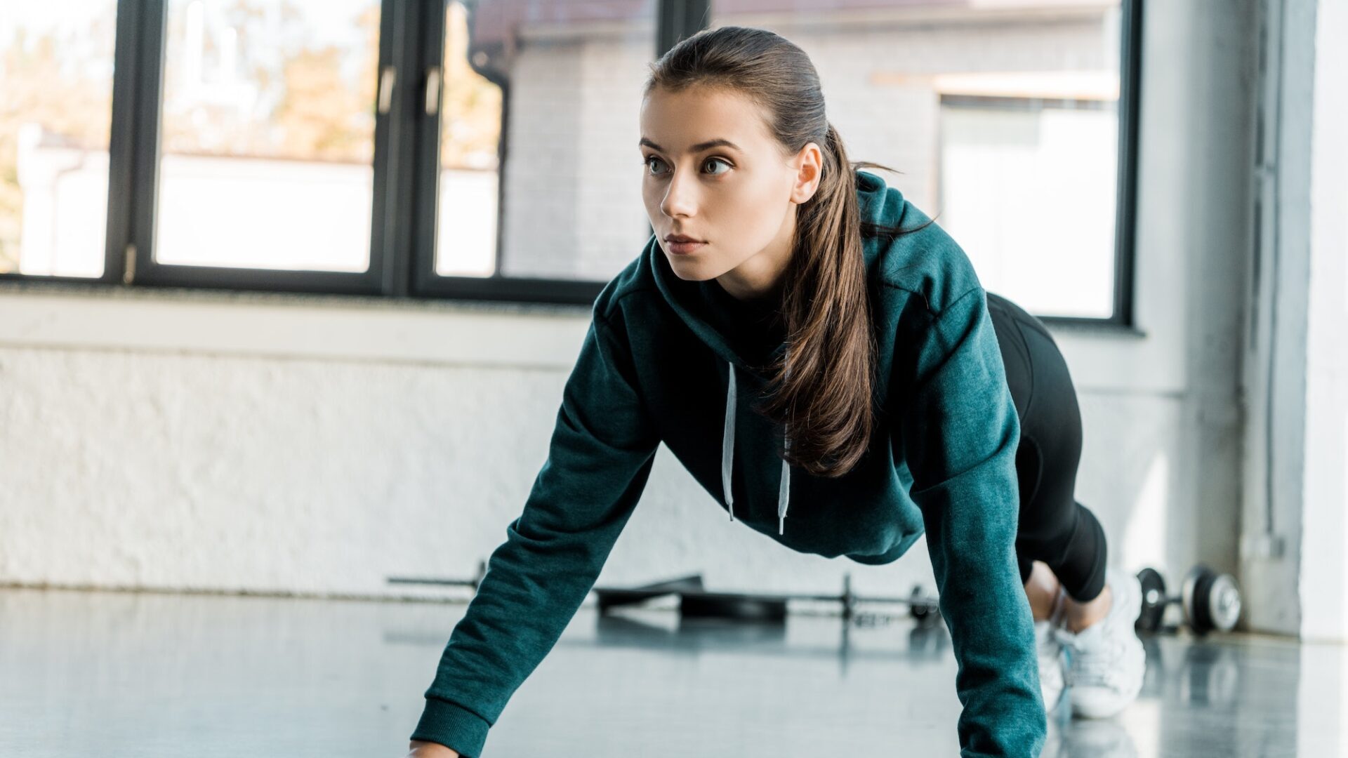 beautiful focused sportswoman doing push ups at sports center